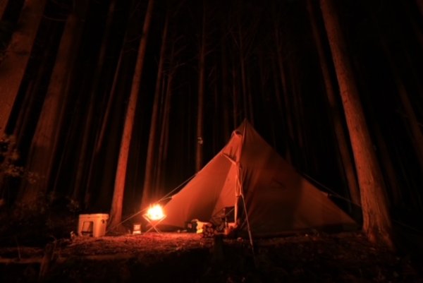 焚火に照らされているテントの写真