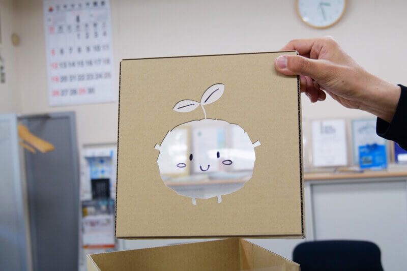ダンボールを型抜きし、プラ素材を貼って当社のキャラクター「マモリン」を表現